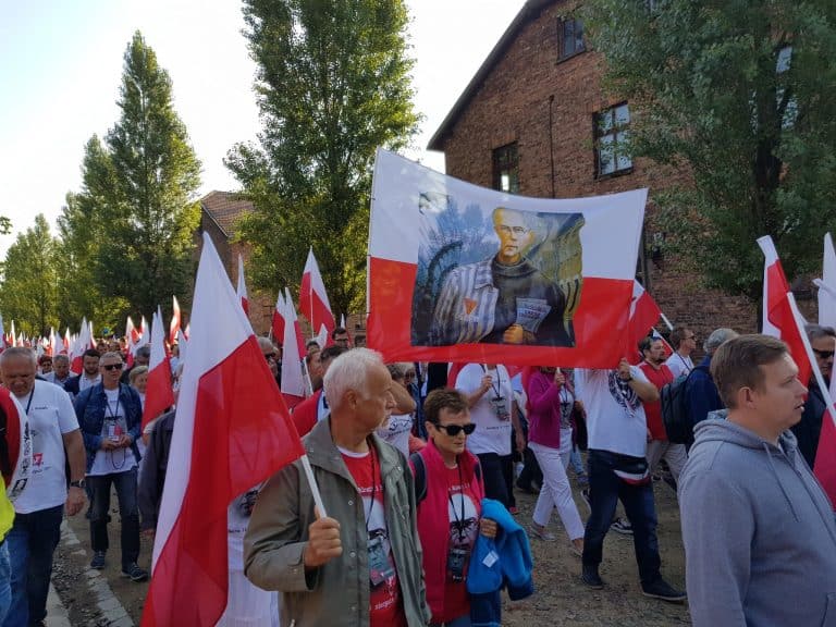Uczestnicy Marszu Życia Polaków i Polonii z biało-czerwonymi flagami w KL Auschwitz